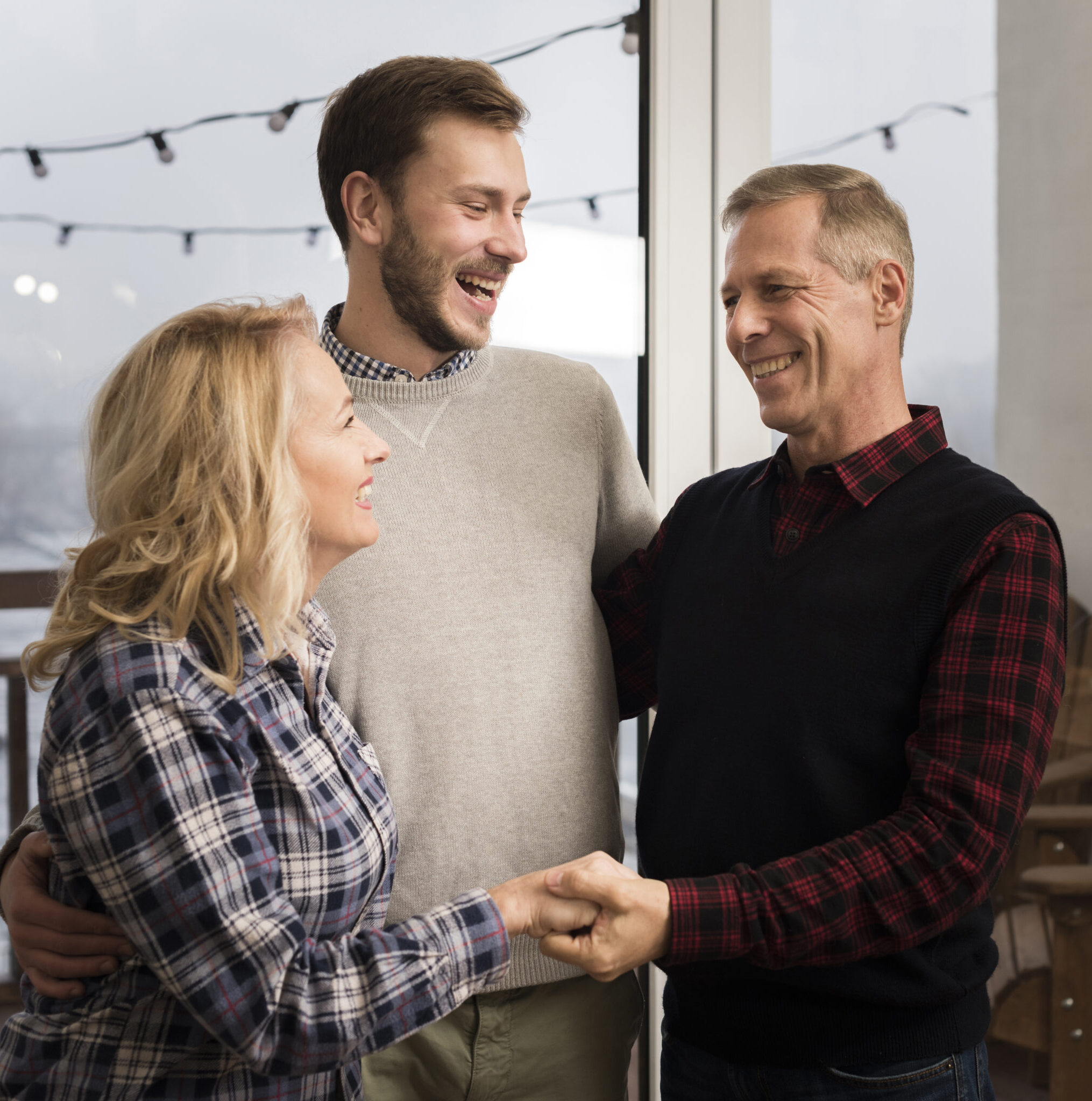 smiley-parents-embracing-son-home
